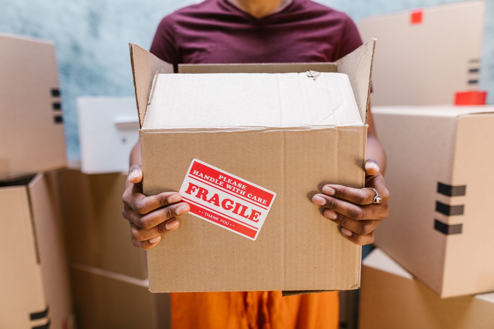 Carton de déménagement marqué fragile, tenu à deux mains
