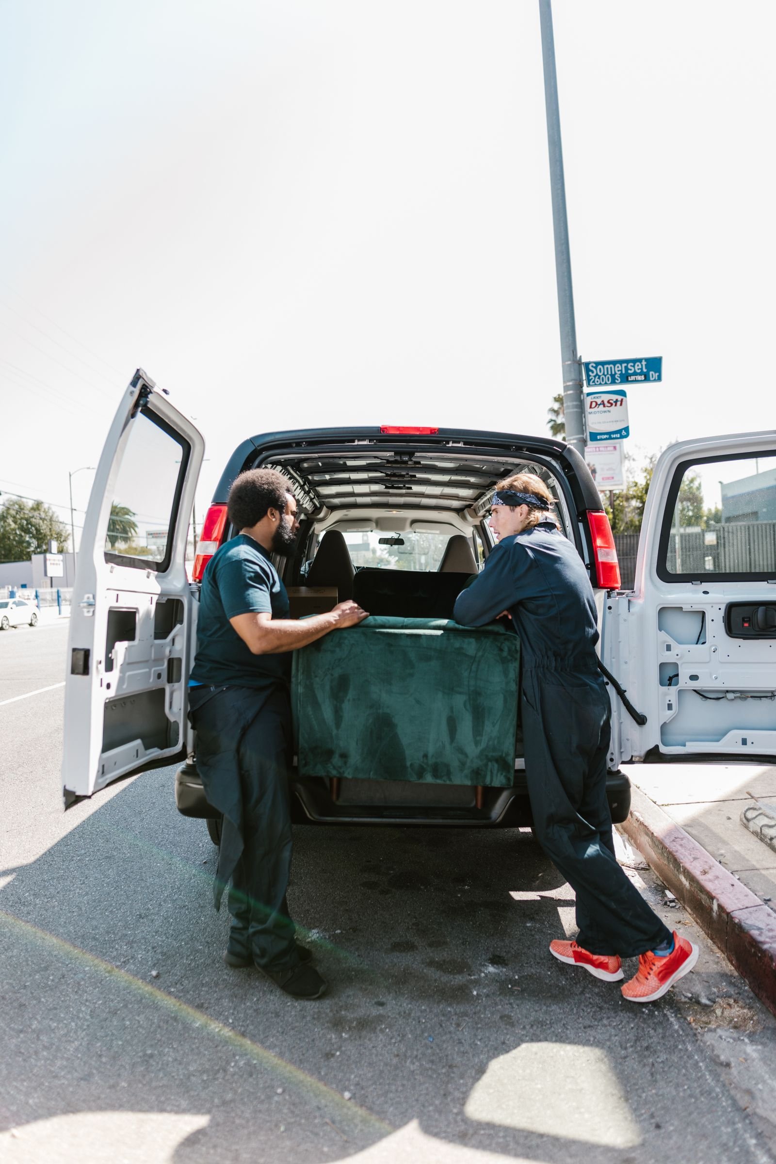 Deux déménageurs chargent des meubles dans un utilitaire