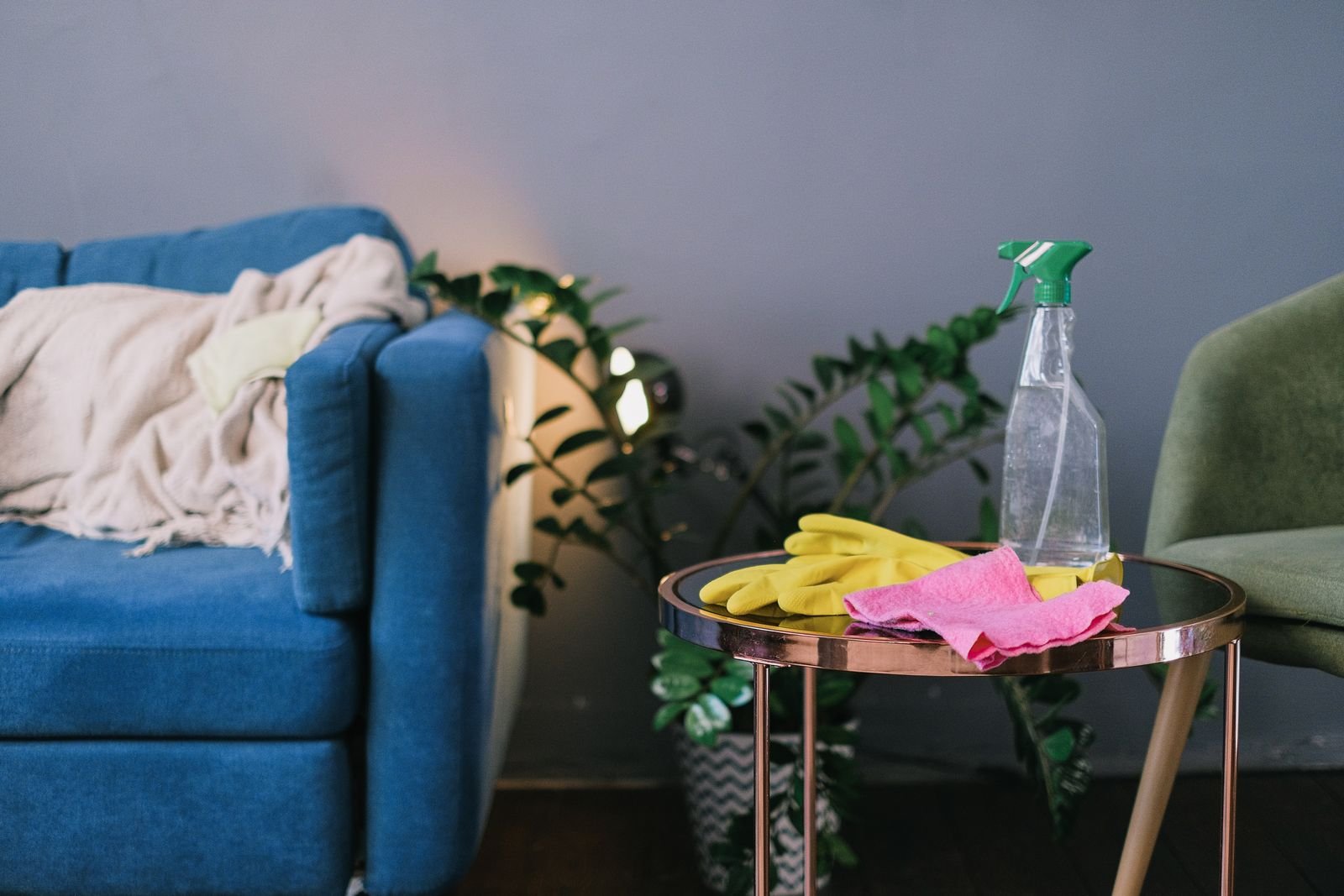 Gants et produit ménager posés sur une table de salon