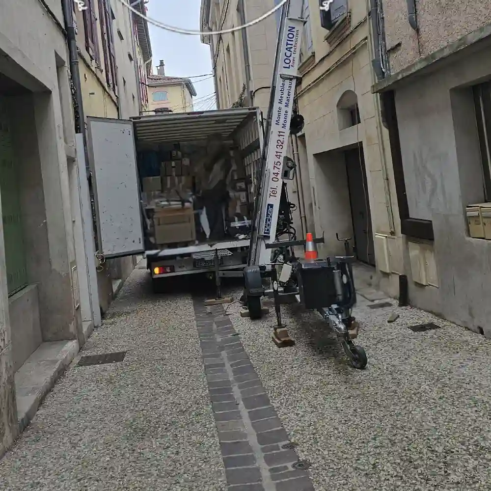 Camion de déménagement et monte-meubles dans une rue étroite