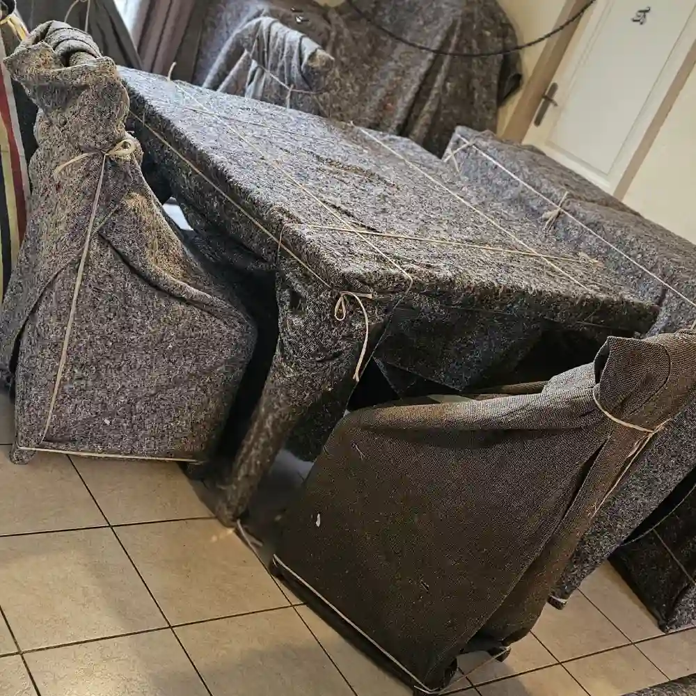 Table et chaises emballées dans des couvertures de déménagement