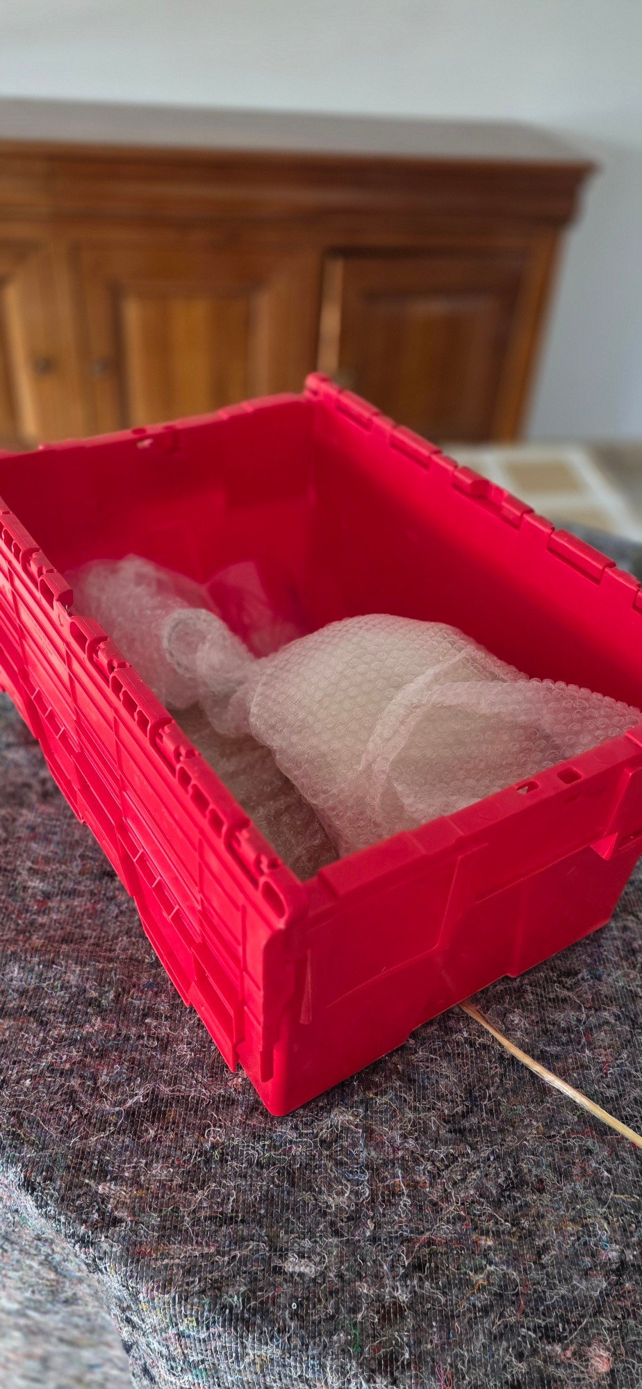 Caisse de déménagement en plastique avec de la vaisselle emballée dans du papier bulle